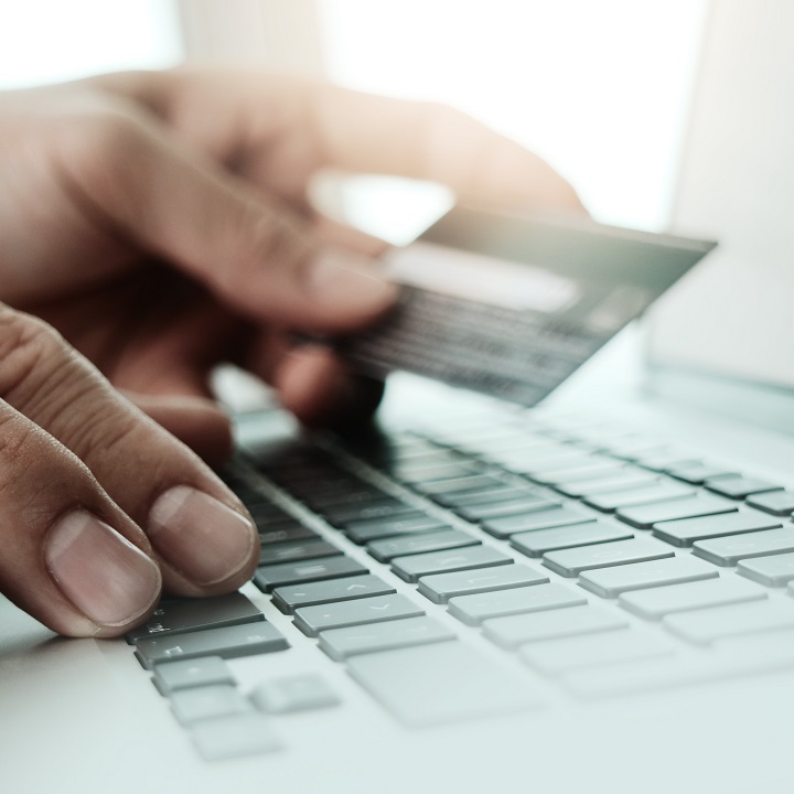 close up of hands using laptop and holding credit card as Online shopping concept